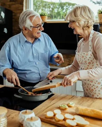 A couple in their sixties cooking together in the kitchen